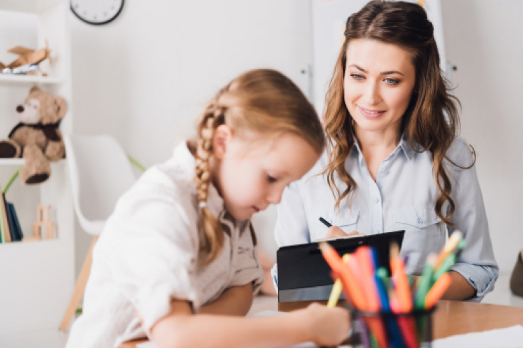 femme-endant-ecriture Femme qui montre la prononciation de la lettre A à une enfant