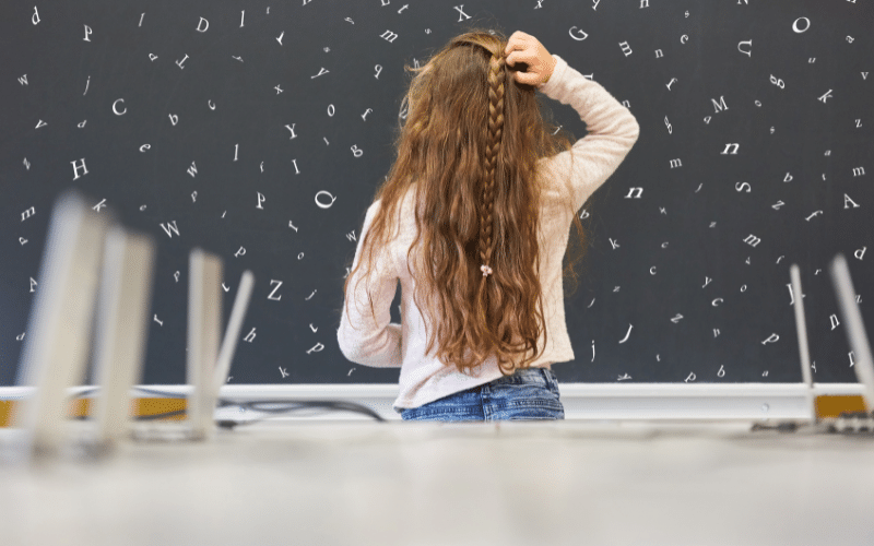 jeune fille dyslexique devant un tableau noir